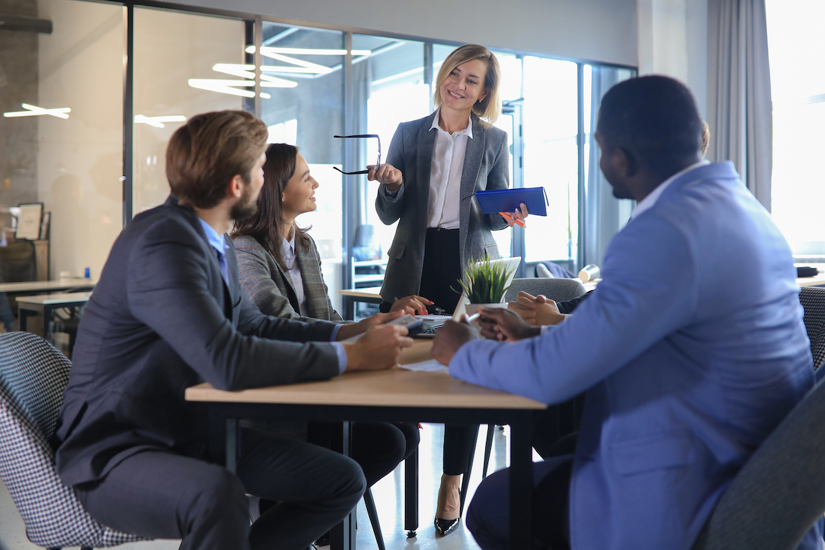 People Give Feedback Around An Office Table On Web Development Project