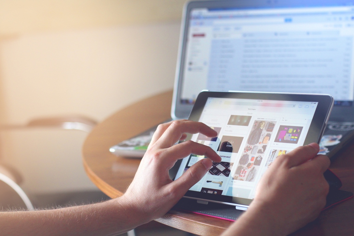 Hands browsing through tablet that has a lot of features being shown on the screen.