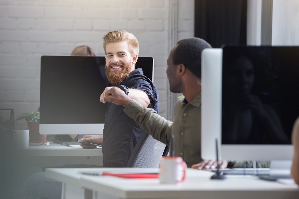 smiling bearded man-giving fist bump male colleague