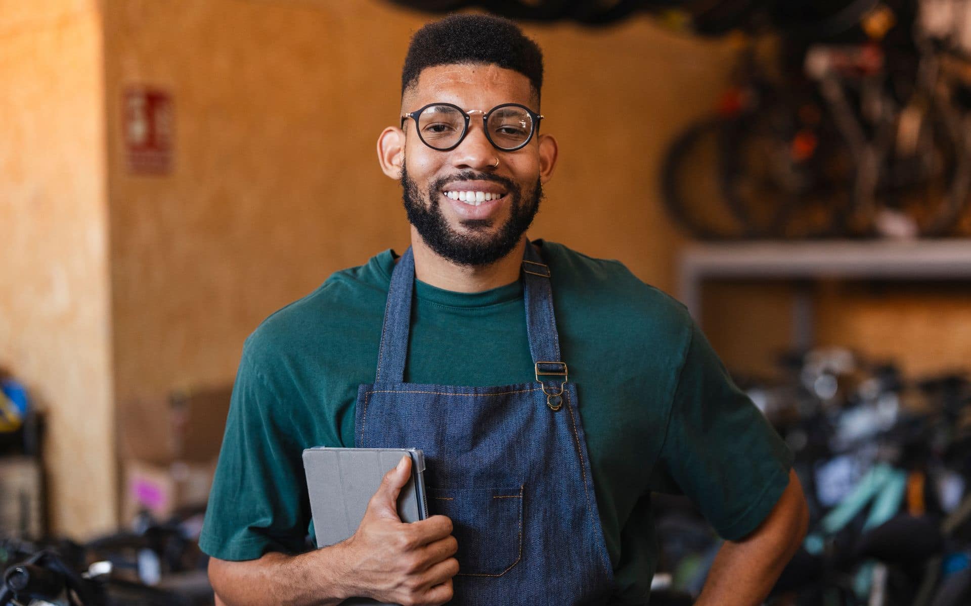 Small Business Owner In Apron Holding A Tablet In A Workshop